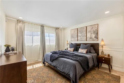 a bedroom with a bed and a dresser next to a window