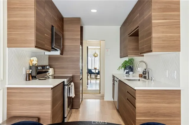 a kitchen with stainless steel appliances granite countertop a sink stove and refrigerator