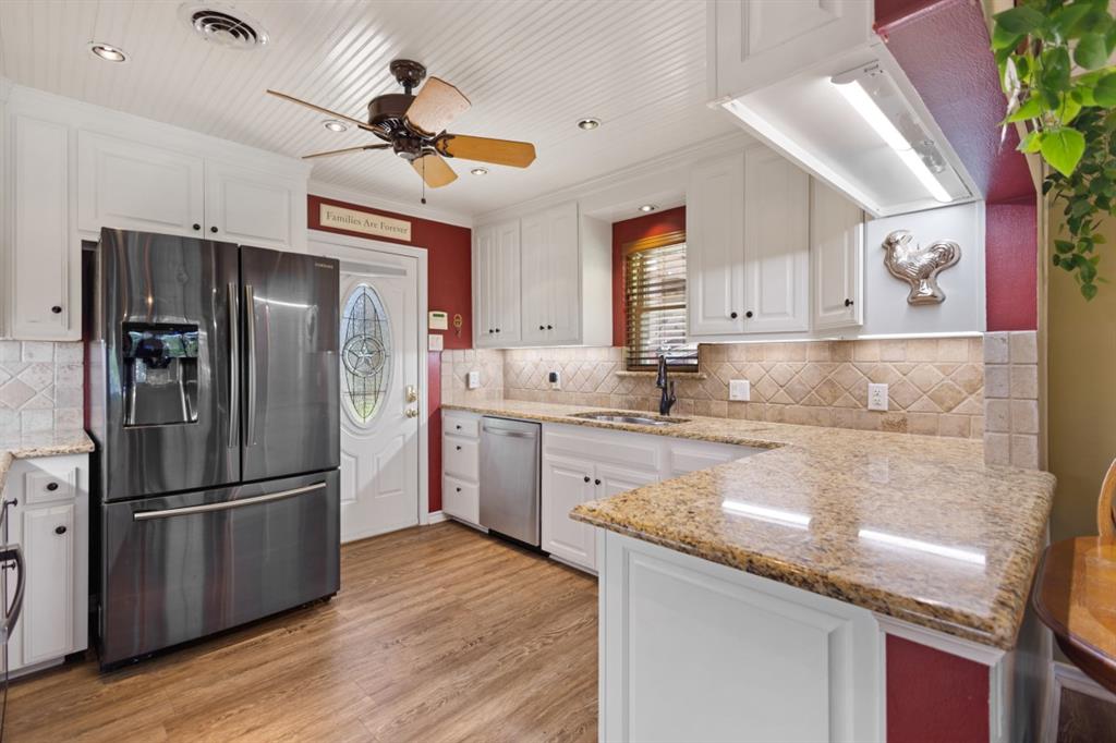 227 Scenic Road Trinidad, TX 75163 - Photo 9 of 40 a kitchen with stainless steel appliances granite countertop a refrigerator a sink dishwasher a stove and white cabinets with wooden floor