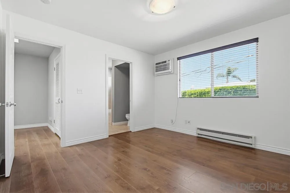 545 Bonair Way La Jolla, CA 92037 - Photo 19 of 57 an empty room with wooden floor and windows