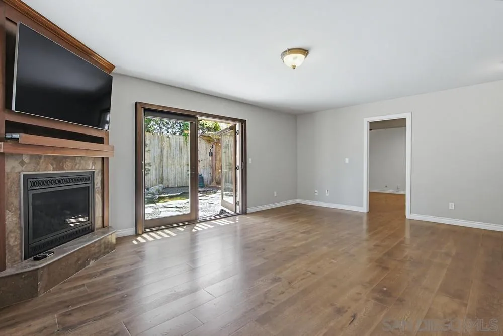 545 Bonair Way La Jolla, CA 92037 - Photo 2 of 57 a view of an empty room with wooden floor fireplace and a window