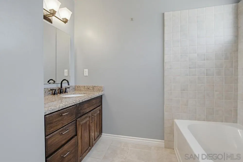 545 Bonair Way La Jolla, CA 92037 - Photo 25 of 57 a bathroom with a granite countertop sink a mirror and a bathtub