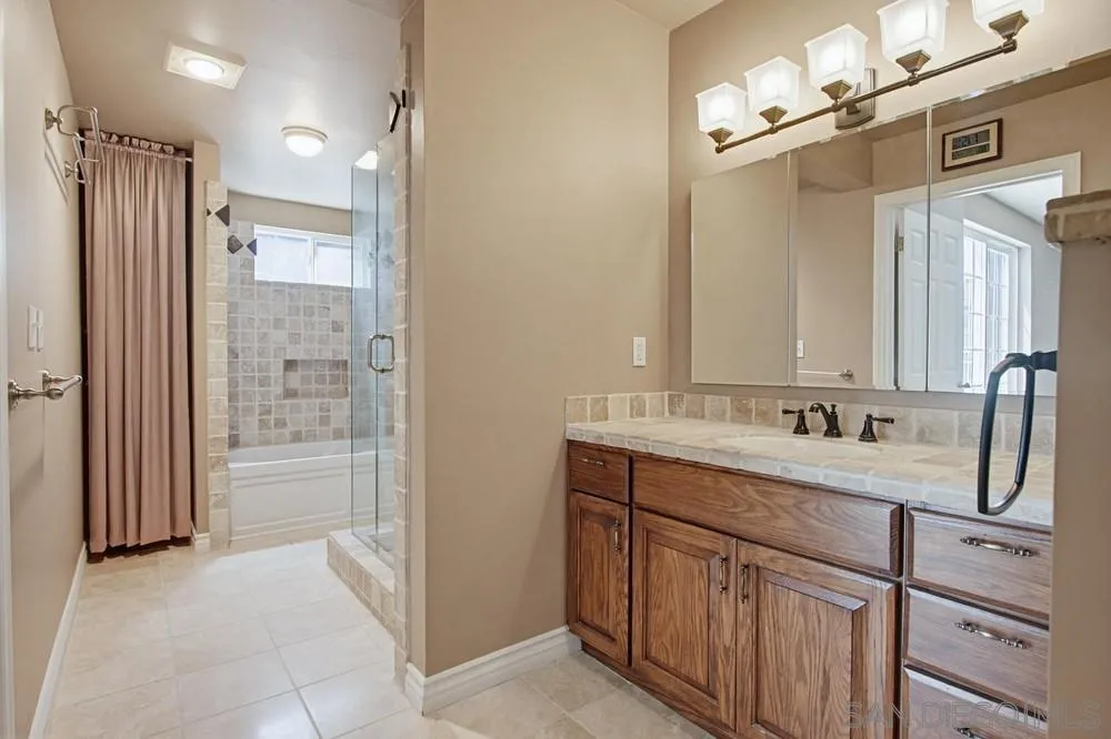 545 Bonair Way La Jolla, CA 92037 - Photo 27 of 57 a bathroom with a double vanity sink a mirror and a shower