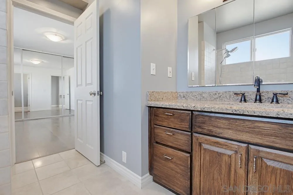 545 Bonair Way La Jolla, CA 92037 - Photo 33 of 57 a bathroom with a granite countertop sink and a mirror