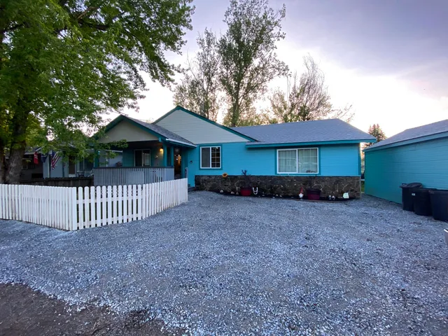 a view of a house with a yard and wooden fence