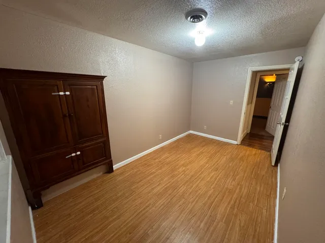 an empty room with wooden floor and mirror