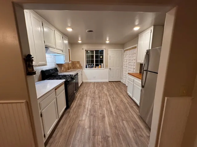 a kitchen with sink a refrigerator and cabinets