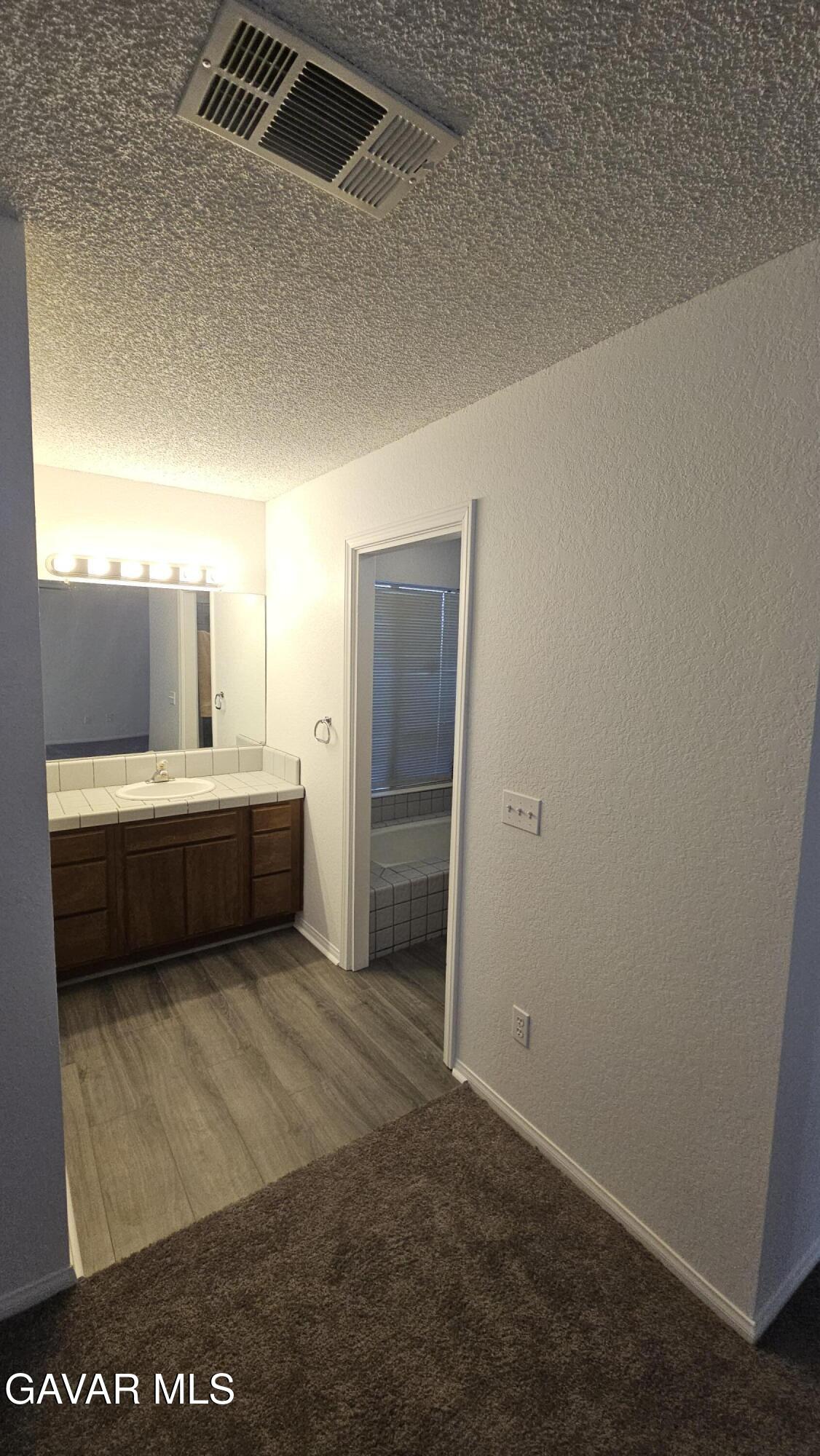 39005 161st Street East Palmdale, CA 93591 - Photo 17 of 27 a bathroom with a sink a mirror and a bathtub