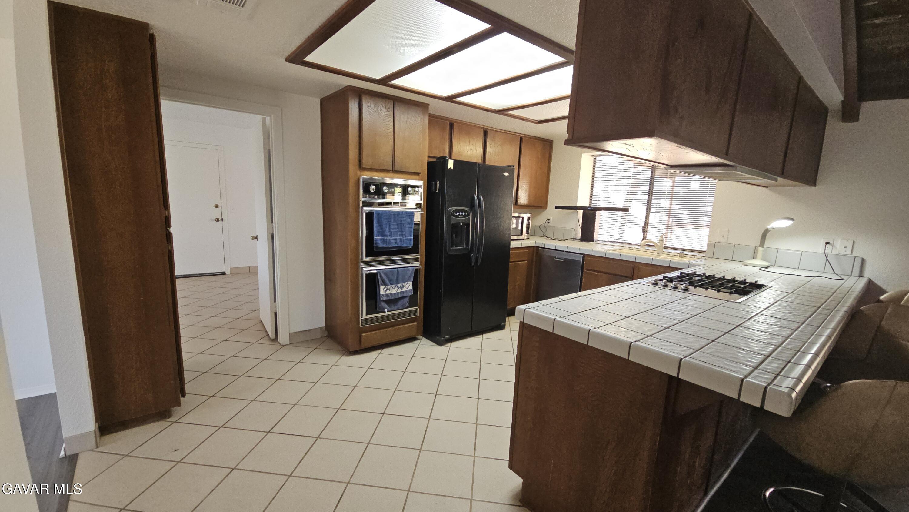 39005 161st Street East Palmdale, CA 93591 - Photo 7 of 27 a view of a kitchen with refrigerator and furniture