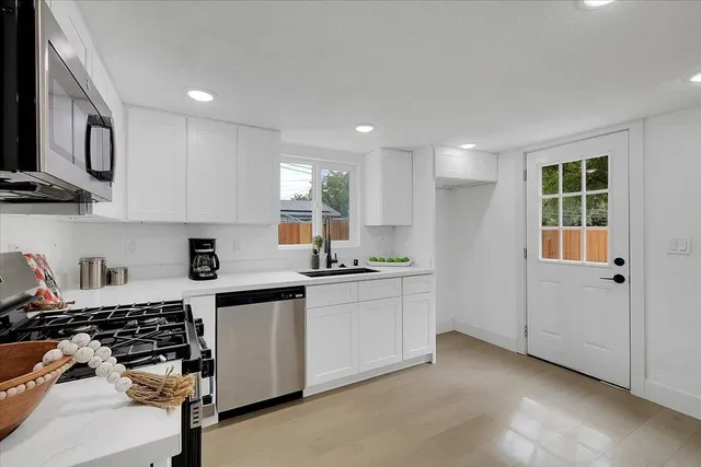 a kitchen with stainless steel appliances granite countertop a stove and a sink