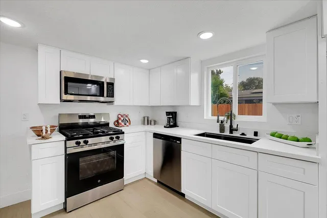 a kitchen with a sink stove and microwave
