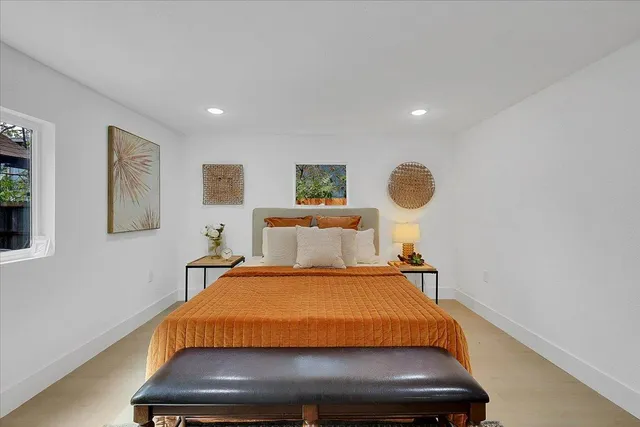 a bed room with a bed and painting on the wall