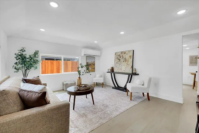 a living room with furniture and a hard wood floor