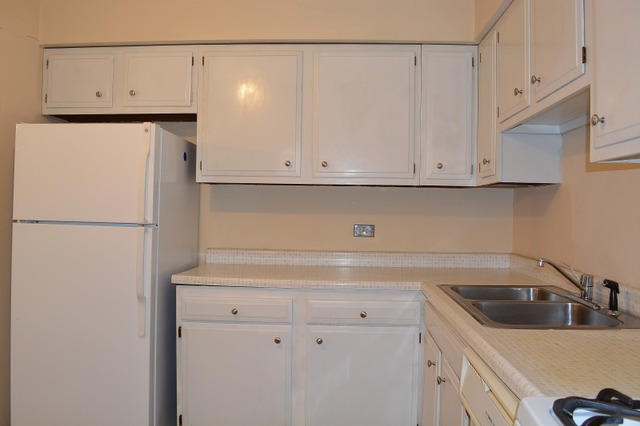 10389 Dearlove Road, Unit 2D Glenview, IL 60025 - Photo 7 of 12 a kitchen with white cabinets and white appliances
