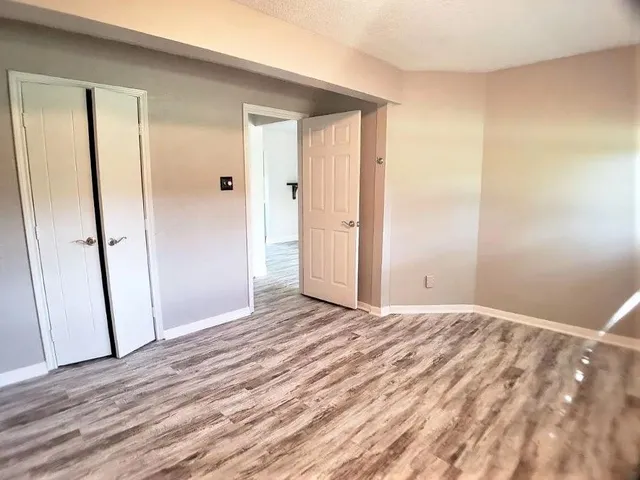 a view of empty room with wooden floor