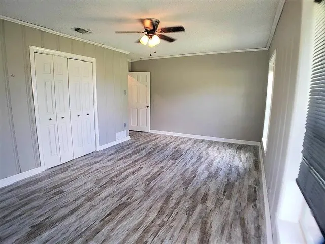 a view of room with hardwood floor and a ceiling fan