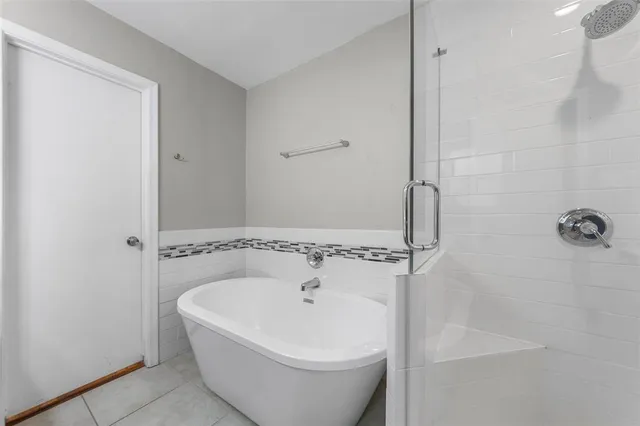 a white bath tub sitting next to a shower