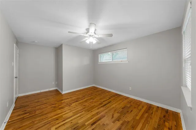 a view of a big room with wooden floor and a chandelier fan