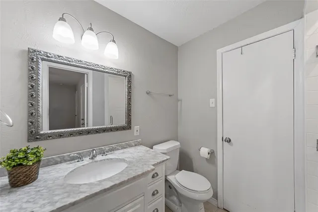 a bathroom with a granite countertop sink toilet and shower