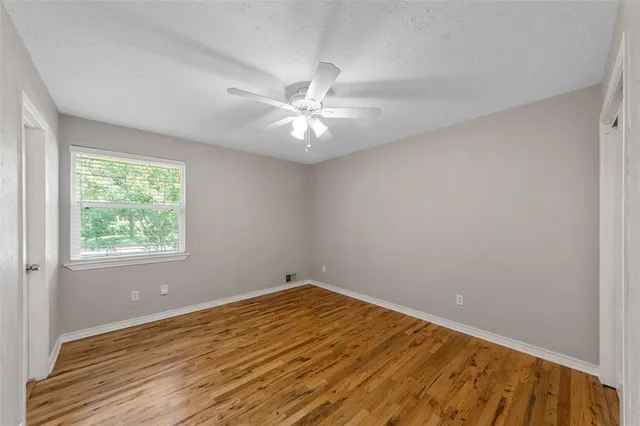 an empty room with a window and a fan