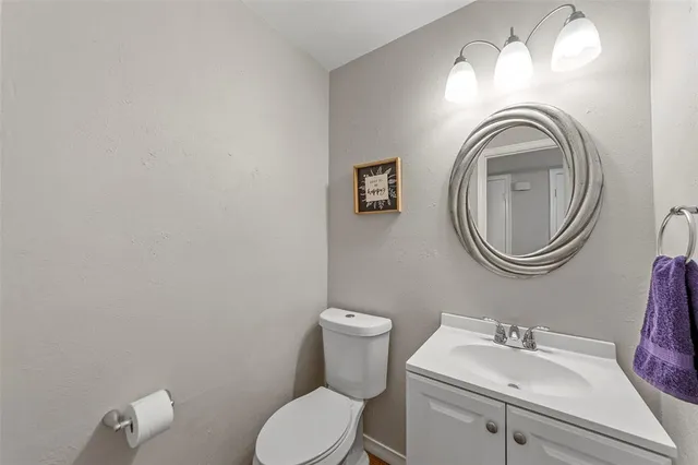 a bathroom with a toilet a sink and a mirror