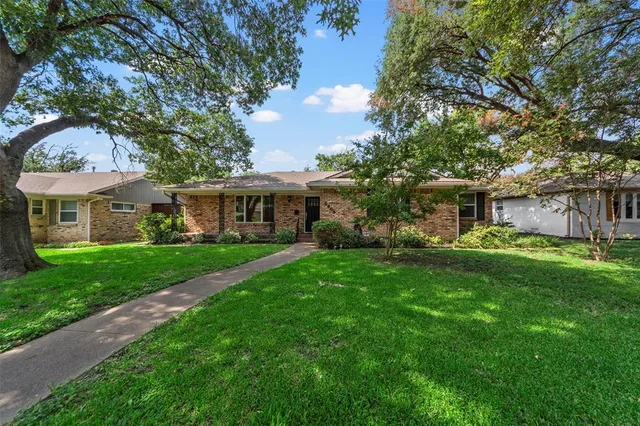 a front view of a house with a garden and yard