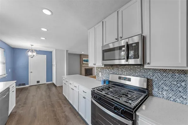 a kitchen with stove and cabinets