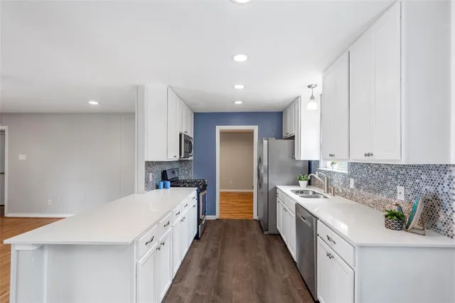 a kitchen with stainless steel appliances sink stove and cabinets