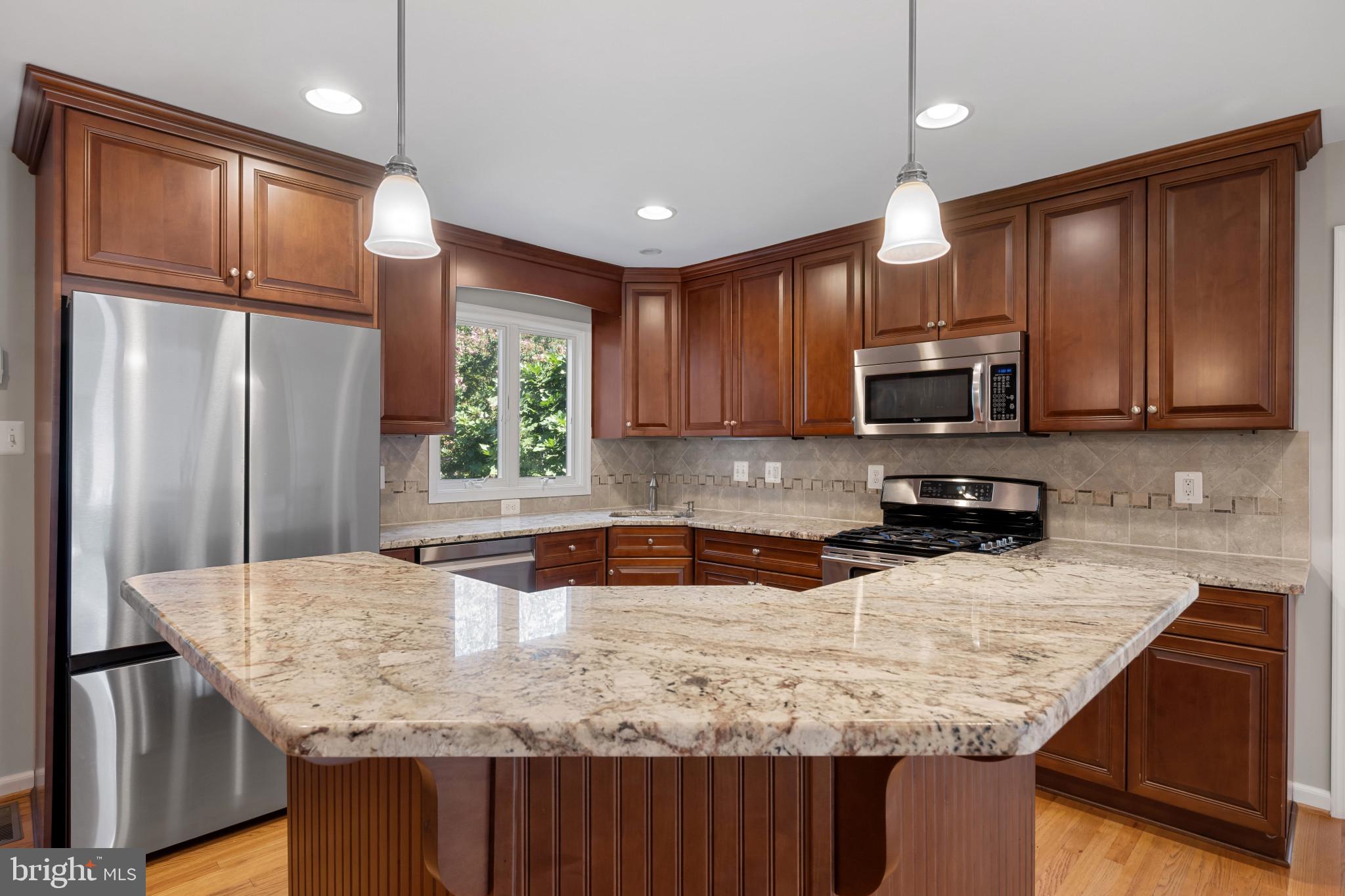 2603 Spartan Road Olney, MD 20832 - Photo 14 of 62 a kitchen with granite countertop a sink a center island stainless steel appliances and cabinets