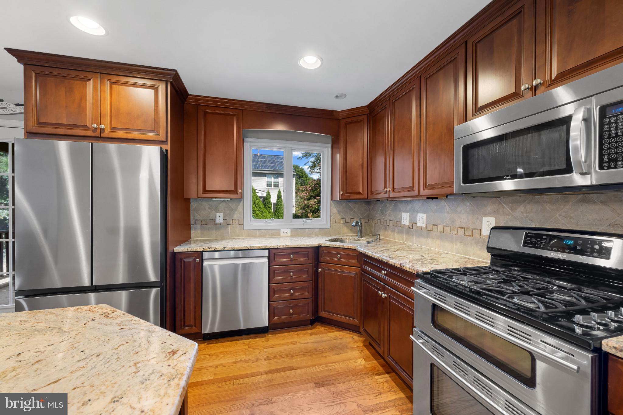2603 Spartan Road Olney, MD 20832 - Photo 15 of 62 a kitchen with stainless steel appliances granite countertop wooden cabinets a stove top oven a sink and dishwasher
