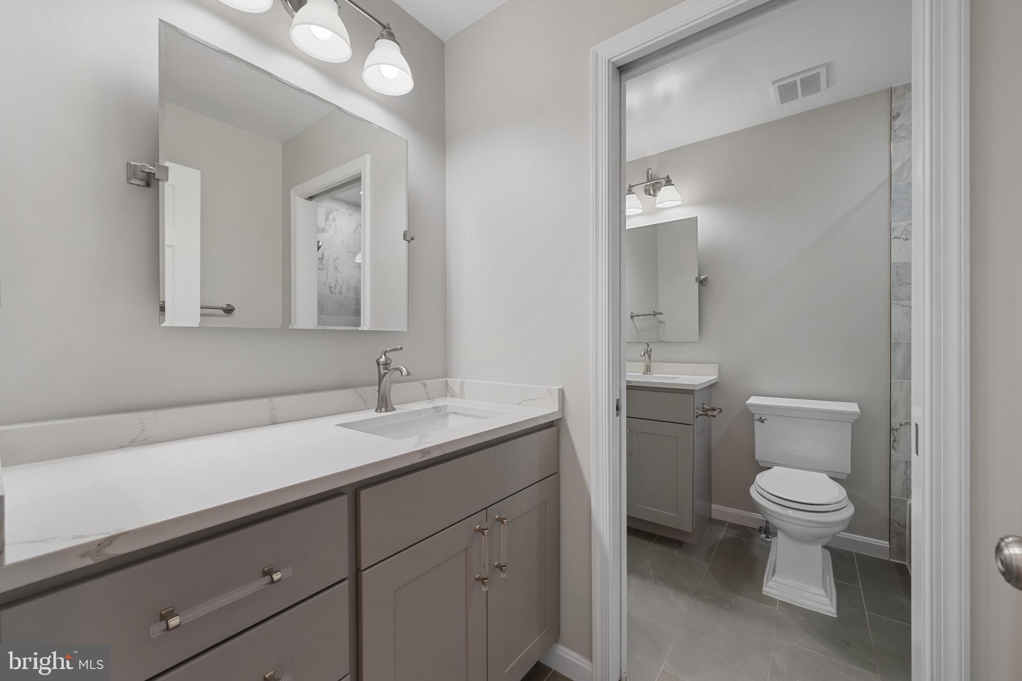 2603 Spartan Road Olney, MD 20832 - Photo 32 of 62 a bathroom with a granite countertop sink a toilet and a mirror