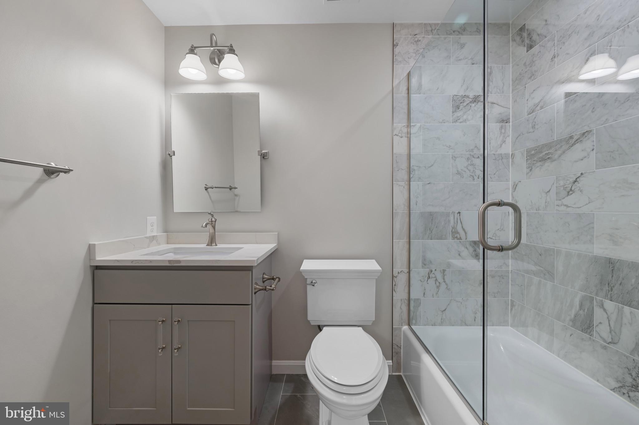 2603 Spartan Road Olney, MD 20832 - Photo 33 of 62 a bathroom with a toilet sink vanity and shower