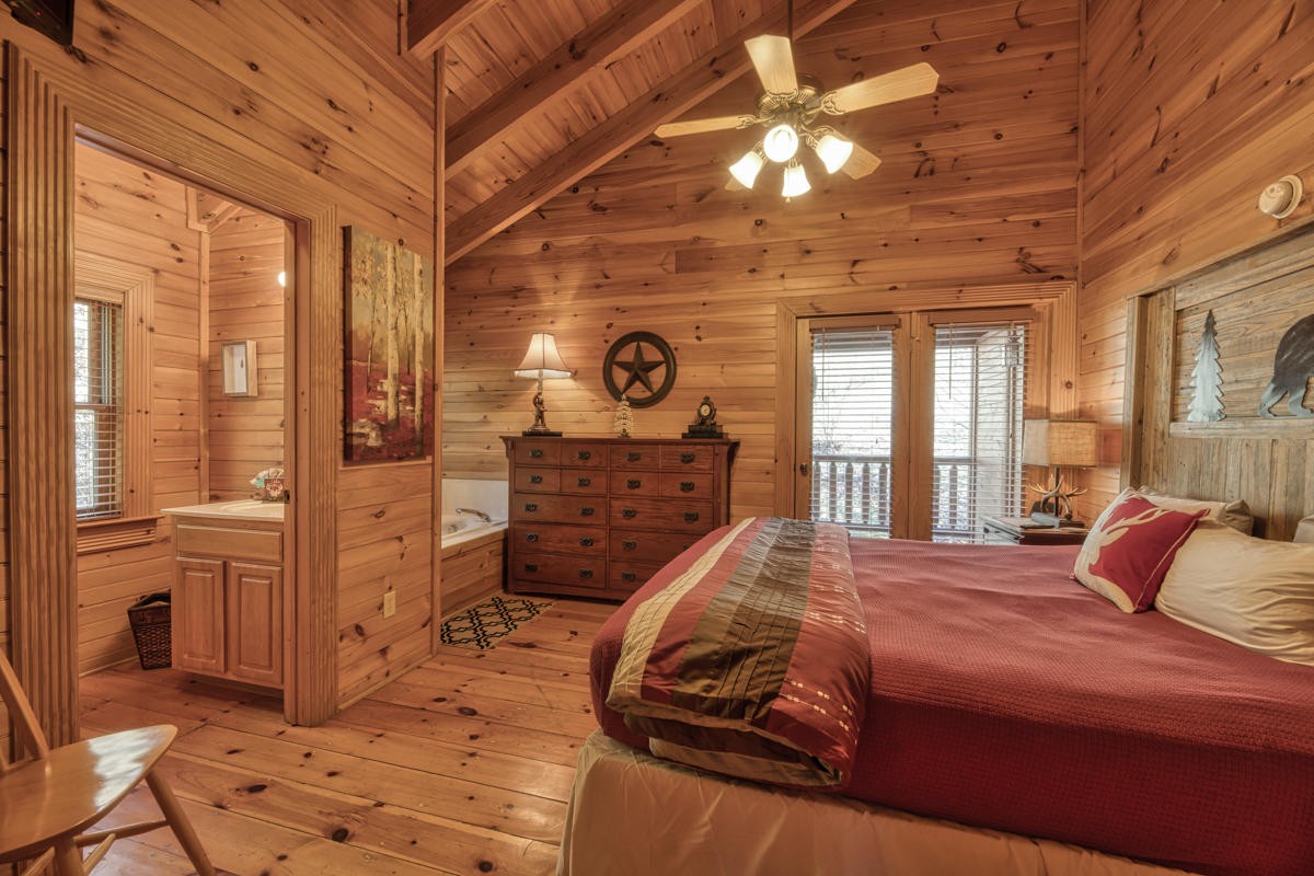 3126 Smoky Ridge Way Sevierville, TN 37862 - Photo 6 of 14 a bedroom with a bed and glass windows