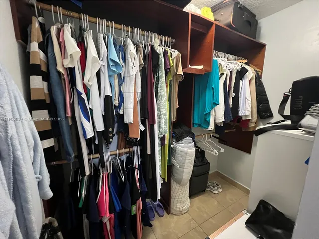 a view of walk in closet with clothes