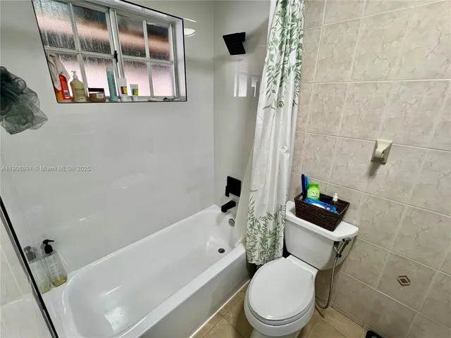 a white toilet sitting next to a bath tub