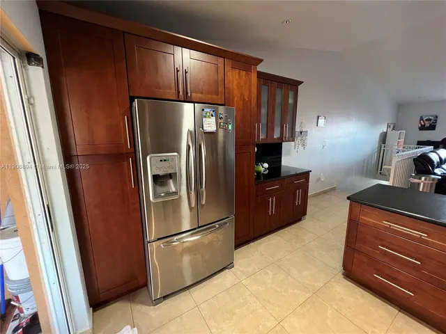 a kitchen with stainless steel appliances granite countertop a refrigerator and a sink
