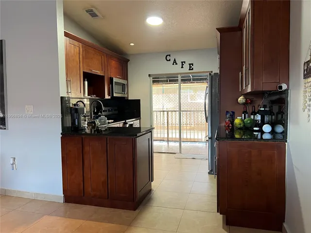 a kitchen with stainless steel appliances granite countertop a refrigerator and a stove top oven