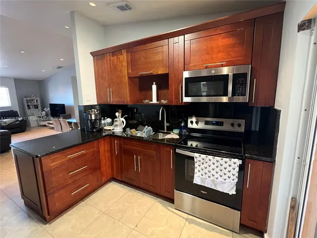 a kitchen with stainless steel appliances granite countertop a stove and a sink