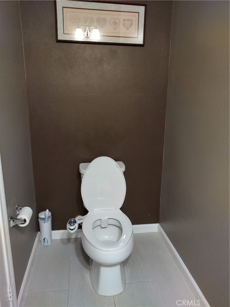 11811 Cramer Road Yucaipa, CA 92399 - Photo 22 of 56 a white toilet sitting in a bathroom next to a wooden wall