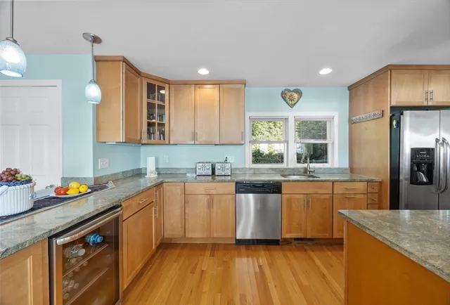 a kitchen with stainless steel appliances granite countertop a sink a stove and refrigerator