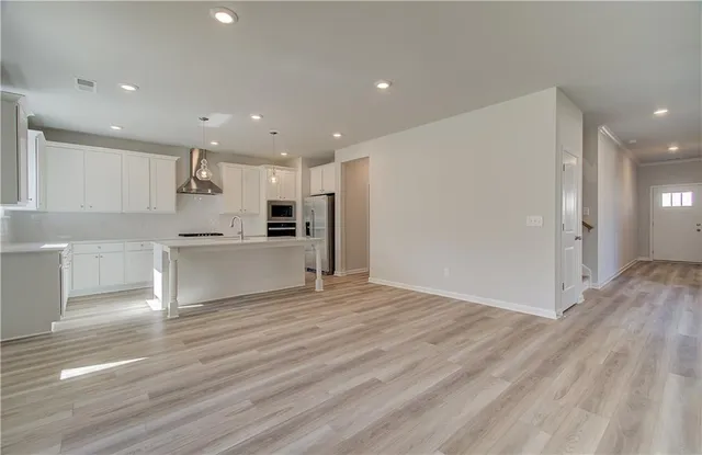 a view of kitchen with kitchen island and stainless steel appliances