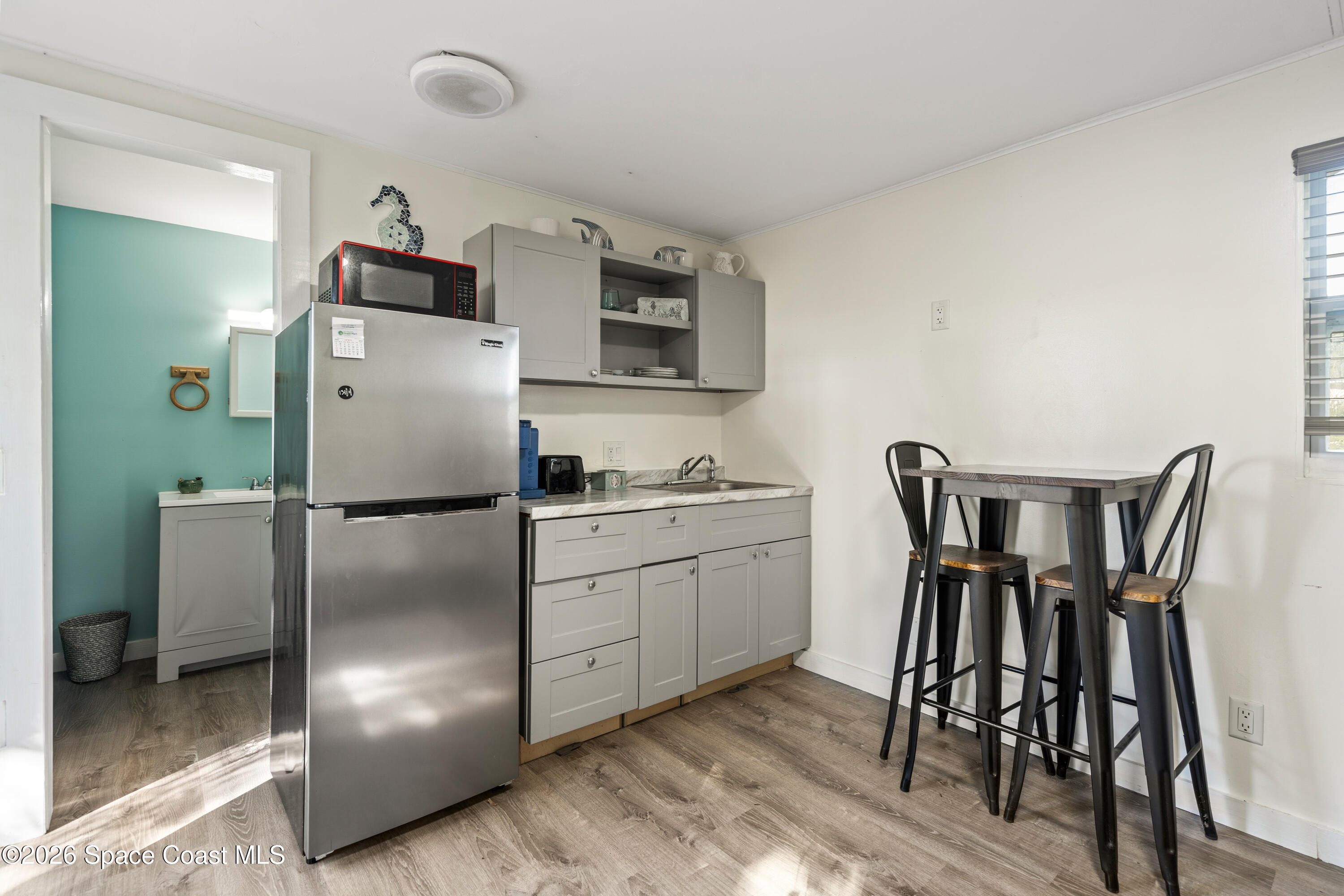8280 Pine Ridge Trail Sebastian, FL 32976 - Photo 14 of 43 a kitchen with a refrigerator and wooden floor