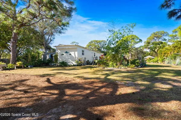 an aerial view of a house with a yard and trees