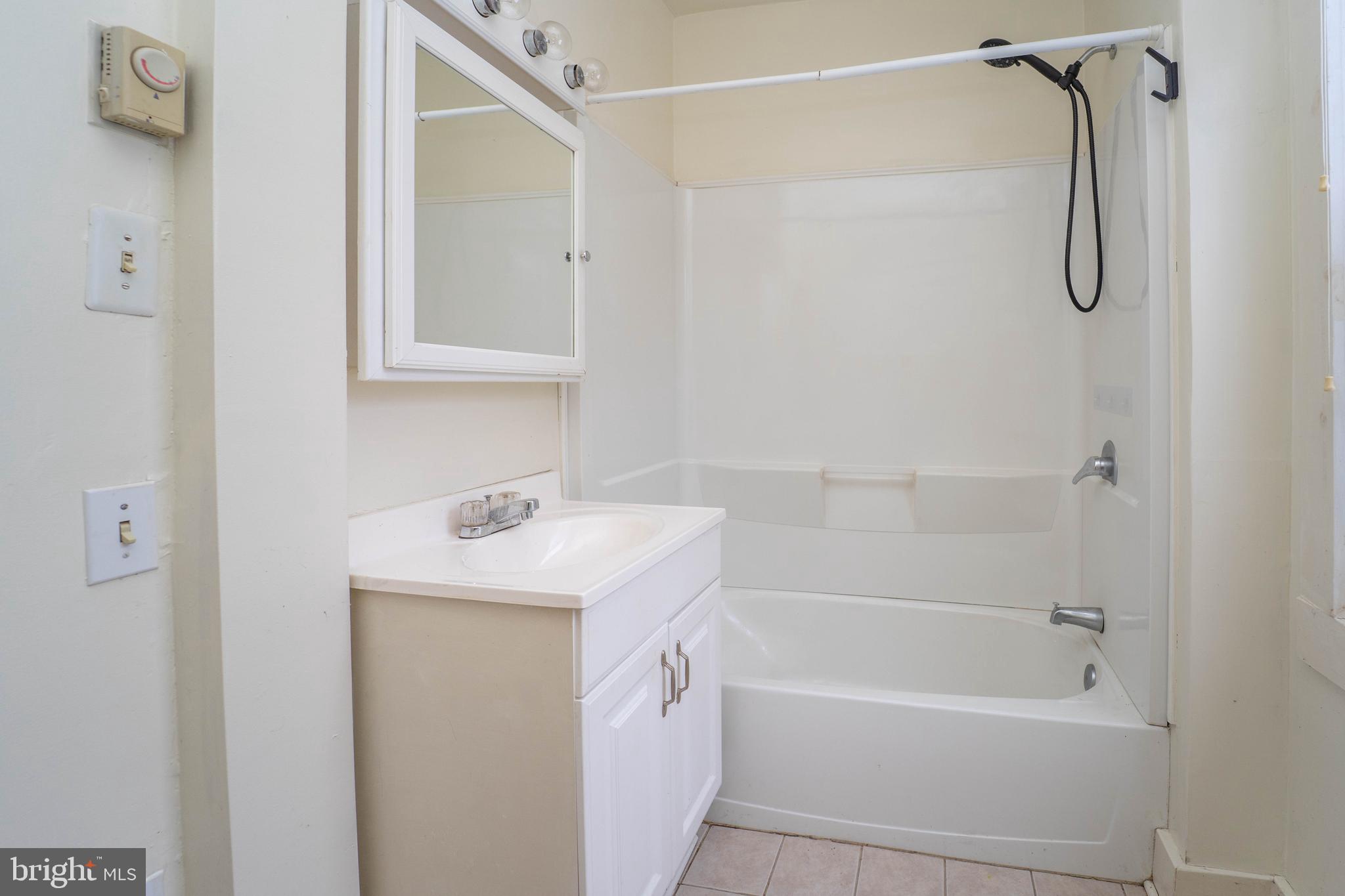 3204 Batavia Avenue Baltimore, MD 21214 - Photo 12 of 31 a bathroom with a sink a mirror and a bathtub