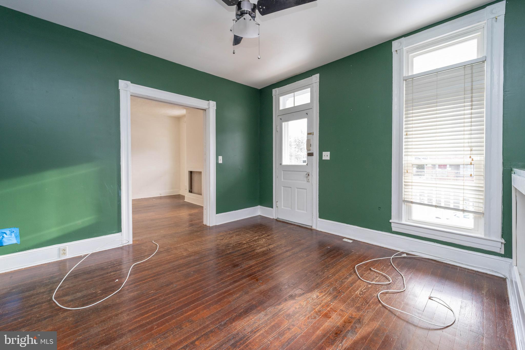 3204 Batavia Avenue Baltimore, MD 21214 - Photo 2 of 31 an empty room with wooden floor fan and windows