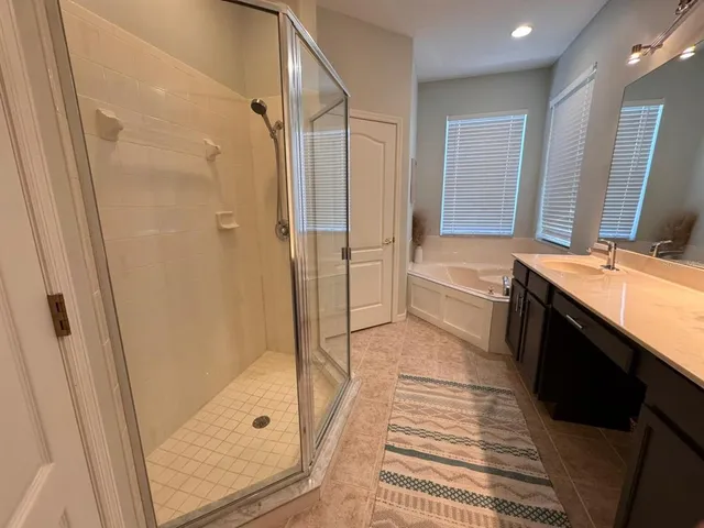 a bathroom with a double vanity sink a toilet a mirror and shower