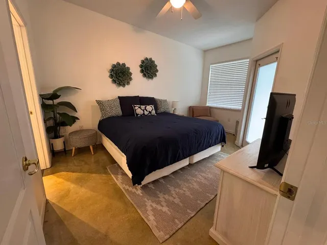 a bedroom with a bed and a flat tv screen on the dresser