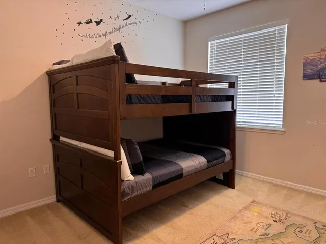 a bed sitting in a bedroom next to a window