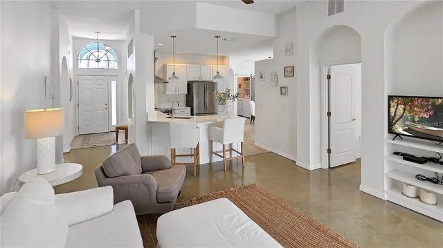 a living room with furniture a large window and a wooden floor