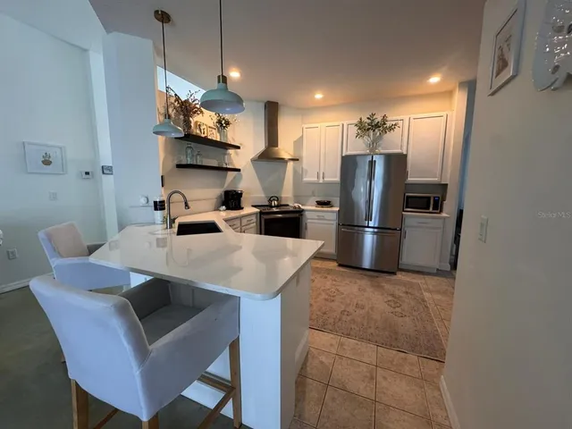 a kitchen with stainless steel appliances granite countertop a sink refrigerator and microwave